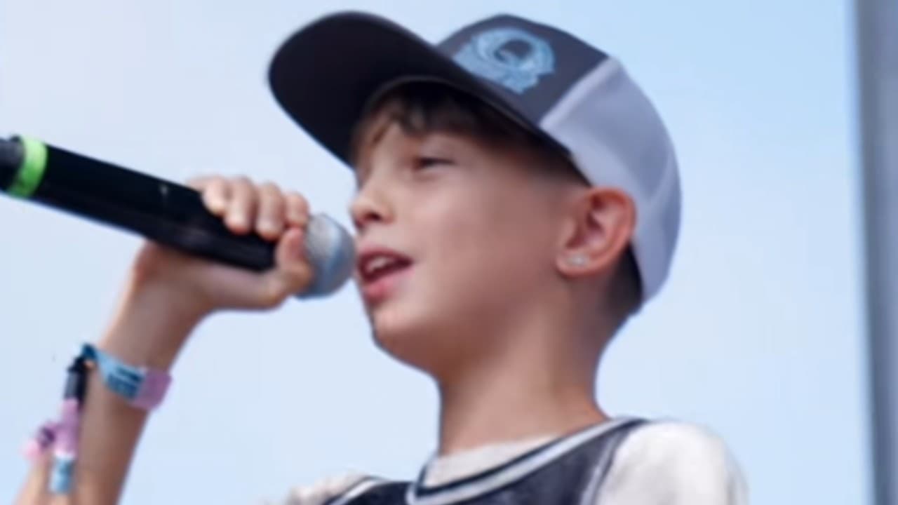 JJQ holding a microphone during the live performance behind the Rin Tin Tin rap meme